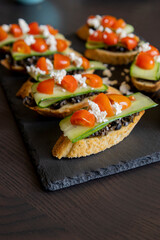 greek crostini with olive paste cucumber tomato and feta close up
