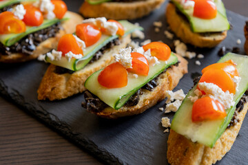 greek crostini with olive paste cucumber tomato and feta close up
