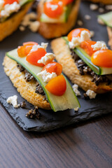 greek crostini with olive paste cucumber tomato and feta close up