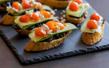 greek crostini with olive paste cucumber tomato and feta close up