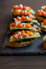 greek crostini with olive paste cucumber tomato and feta close up