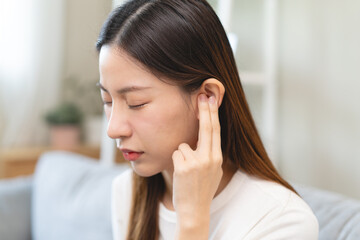 ear problem concept, Young woman touching her ear feel pain from inflammation.