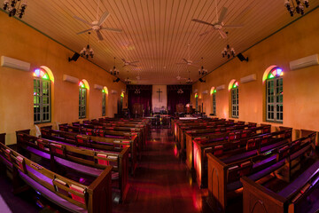 Beautiful interior view of little country church with empty wooden pews.