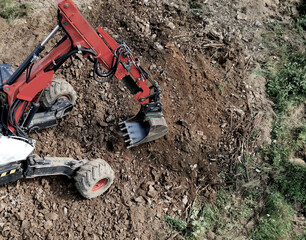 An excavator capable of digging on steep slopes in the mountains. It has adjustable wheel height...