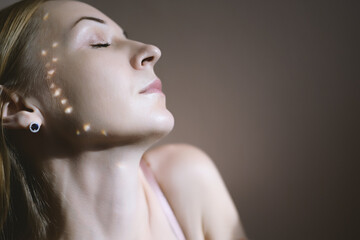 Portrait of a woman with reflected sunlight on her face.