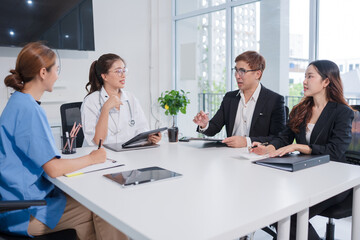 A lone Asian male doctor is working in a hospital conference room.	