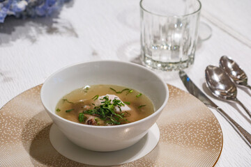 a clear fish soup serving at dinner recption