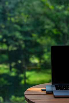 laptop on wooden table connect with memory card reader inserted by camera memory card with ray of sun light spotted on it