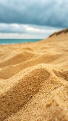 Close up image of sand with blurred sea and sky background. ideal for summer themed products
