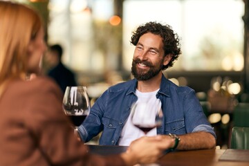 Smiling Couple Enjoying Romantic Dinner and Drinks at a Cozy Restaurant