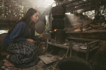 Asian rural woman cooking sticky rice with firewood stove in Thailand. Thai culture, Thai...