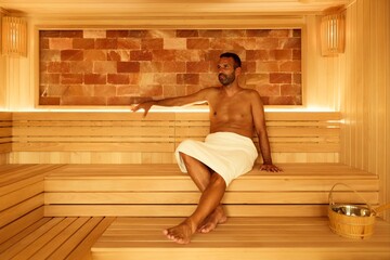 Man Relaxing in a Luxurious Sauna with Himalayan Salt Wall