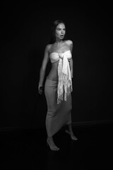 Full length black and white low key portrait of beautiful young woman