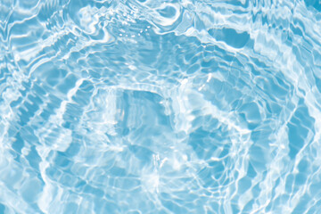 Blue water with ripples on the surface. Defocus blurred transparent blue colored clear calm water surface texture with splashes and bubbles. Water waves with shining pattern texture background.
