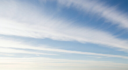 Obraz premium A scenic view of a bright blue sky filled with wispy white clouds on a sunny day in the atmosphere