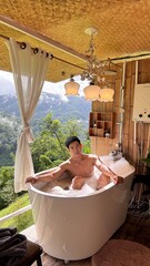 Handsome Man Relaxing in Bubble Bath on Veranda Amidst Lush Green Forest and Gentle Rain