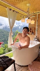 Handsome Man Relaxing in Bubble Bath on Veranda Amidst Lush Green Forest and Gentle Rain