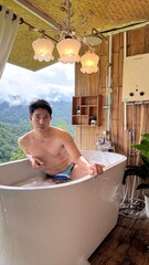 Handsome Man Relaxing in Bubble Bath on Veranda Amidst Lush Green Forest and Gentle Rain