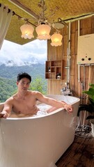 Handsome Man Relaxing in Bubble Bath on Veranda Amidst Lush Green Forest and Gentle Rain
