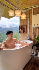 Handsome Man Relaxing in Bubble Bath on Veranda Amidst Lush Green Forest and Gentle Rain