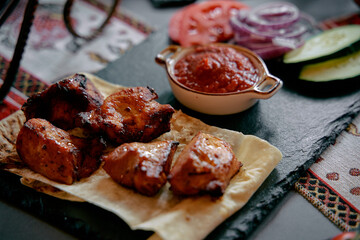 Delicious Grilled Chicken Served on a Traditional Plate with Fresh Vegetables and Spicy Sauce for a Flavorful Dining Experience