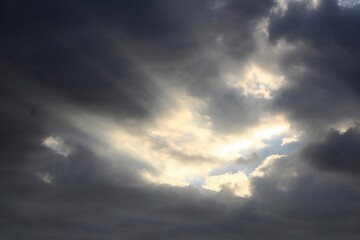 Dramatic Sky: Sunbeams Breaking Through Dark Storm Clouds.