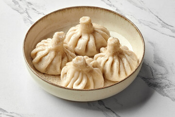Delicious khinkali dumplings served on a plate, sprinkled with black pepper