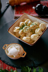 Delicious Homemade Dumplings Served with Creamy Sauce, Garnished with Fresh Herbs on a Rustic Table Setup, Perfect for a Cozy Meal