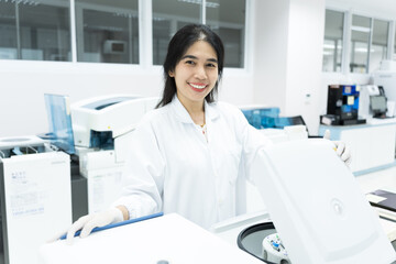 Asian woman scientist and centrifuge for pre analysis blood test in laboratory department.Lab technician using centrifuge device automation machine for testing diagnostic clinical specimens sample.