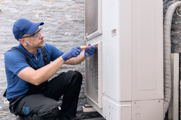 Repairman fixing AC outdoor unit.