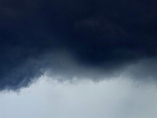 The dynamic atmosphere of the sky and clouds is dark and dense, with the lighter background...