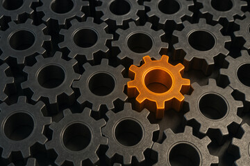 Orange gear standing out among black gears, symbolizing uniqueness, innovation, and the critical role of individuality in teamwork