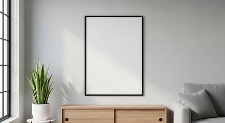 A blank vertical frame mockup hangs on a light gray wall above a wooden sideboard in a minimalist living room.