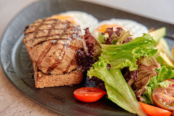 Deliciously Grilled Steak Served on Whole Grain Bread Accompanied by Fresh Salad, Ripe Tomatoes, and Perfectly Cooked Eggs for a Nourishing Meal