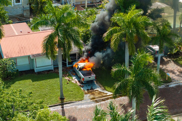 Firefighters extinguishing car fire on suburban street in Florida