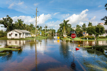 Flooded street in Florida after hurricane rainfall with road closed signs blocking driving of cars....