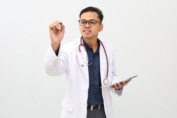 Asian adult male doctor wearing doctor's coat and hanging stethoscope on neck, holding tablet. Pointing with pen or writing something in blank space.