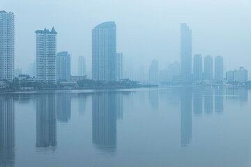 Obraz premium Bangkok office buildings and condominium with Chao Phraya river and chips. Office building under smog in Sathorn Bangkok. Smog PM 2.5 is a kind of air pollution. Bangkok City in the air pollution.
