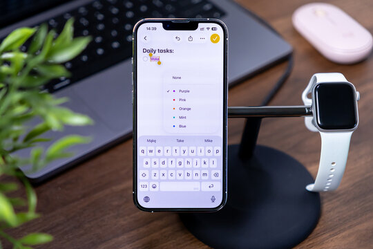 Poznan, Poland - July 29, 2025: Daily tasks application on Apple iPhone displaying ios 26 and Liquid Glass, with Apple Watch, optimizing modern digital productivity