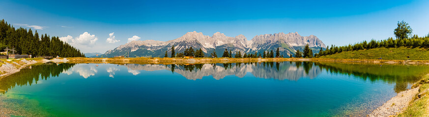 High resolution stitched alpine summer panorama with reflections in a lake and Mount Wilder Kaiser...