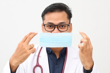 Happy young asian doctor standing holding wearing face mask. Isolated on white background. Close up