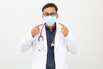 Happy young asian doctor standing wearing face mask. Isolated on white background. Close up