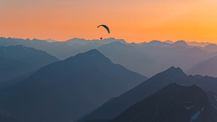 Alpine sunset or sundowner with a paraglider at Mount Zugspitze, Top of Germany, Garmisch,...