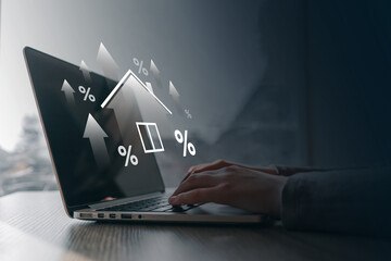 Close-up of hands typing on a laptop with floating financial icons and percentage arrows,...