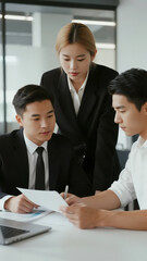 Fototapeta premium Three professionals in a meeting, reviewing documents and discussing strategies.