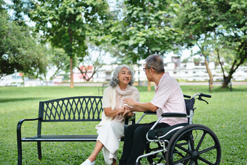 Happy Asian senior couple sharing moments in park