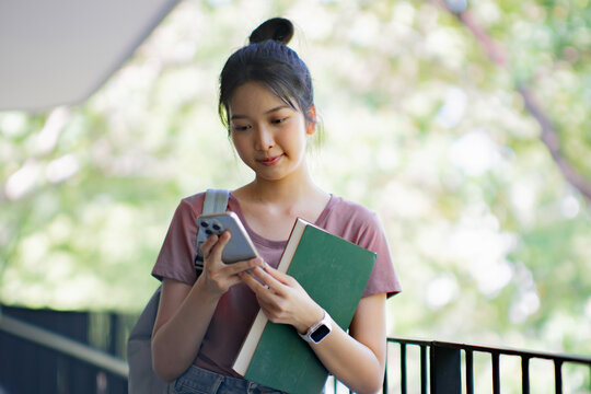 Asian girl using cell phone for checking social media at home holding smartphone in morning - Powered by Adobe