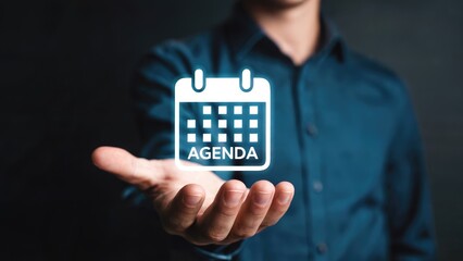 Businessman presents glowing digital calendar agenda icon, symbolizing planning and organization for success.