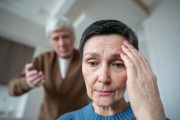 Woman with headache in depression, sad and upset from hysterical husband screams in background....