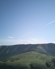 Panoramic Vista of green farmin grass peaks, Cantabria - Bask in breathtaking views of Alto Campoos...